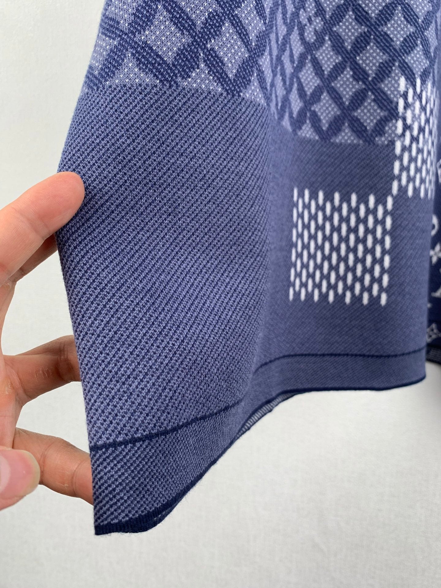 Navy blue short-sleeve shirt side view with textured knit and check patch area.
