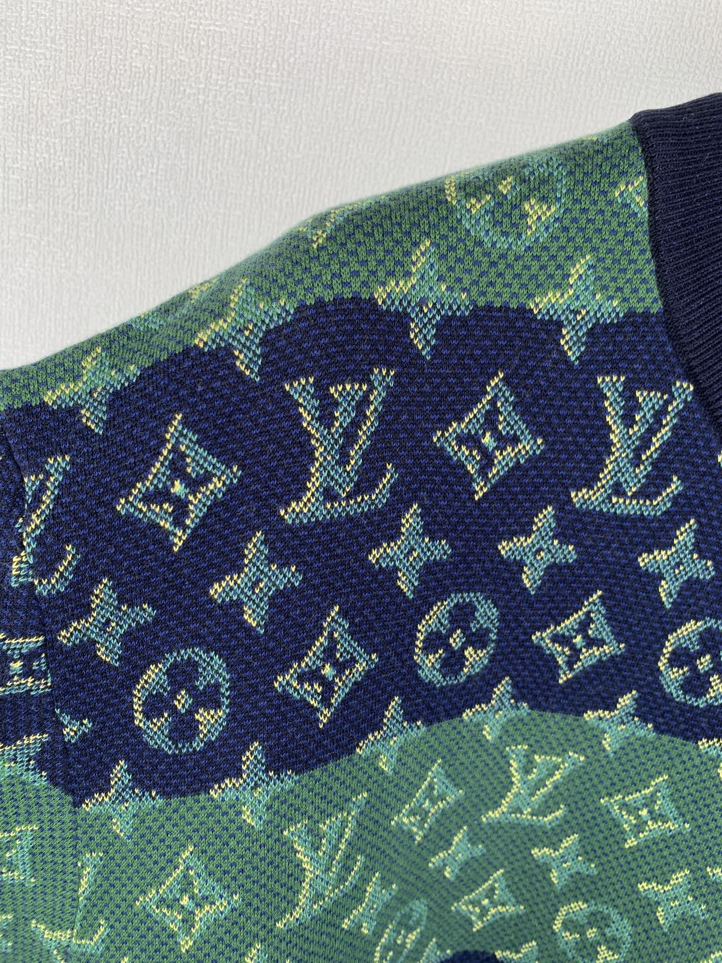 Louis Vuitton knit T-shirt fabric detail in green with navy monogram icons.