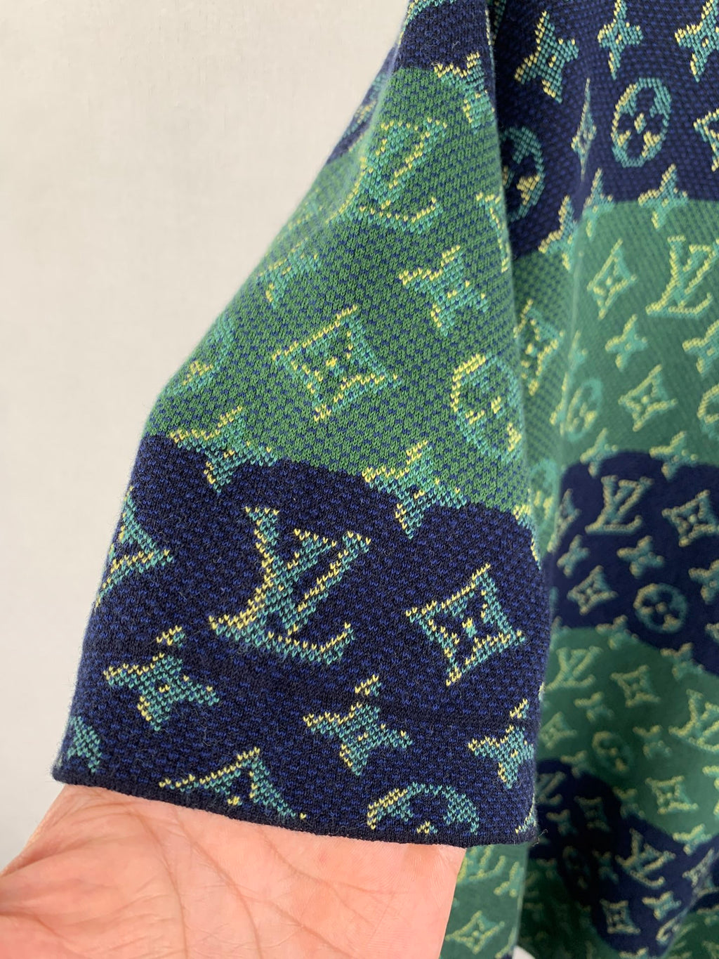 Louis Vuitton knit T-shirt sleeve edge and side seam, green and navy monogram pattern.