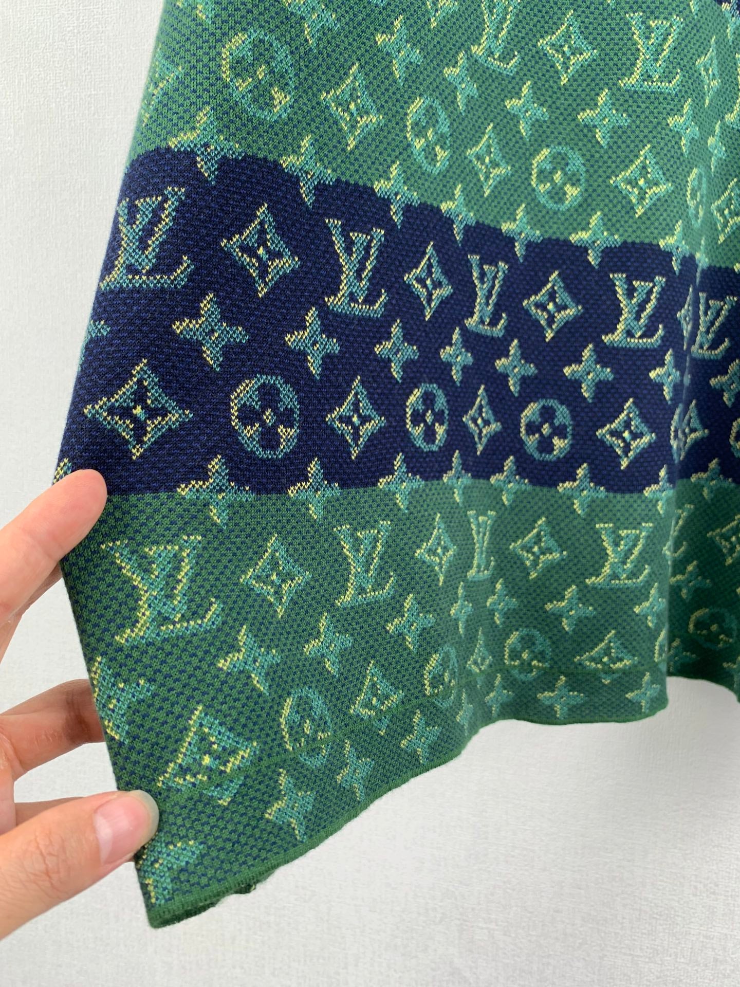 Louis Vuitton knit T-shirt hem corner with green and navy monogram pattern.