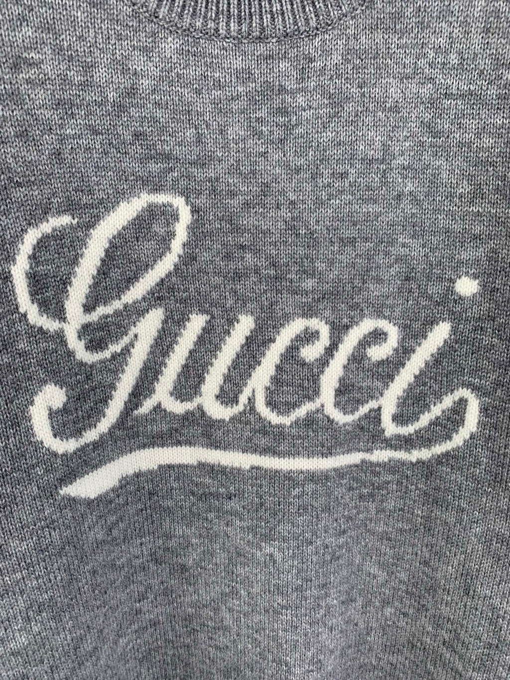 Gray knit sweater front with white Gucci script logo