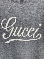 Gray knit sweater front with white Gucci script logo