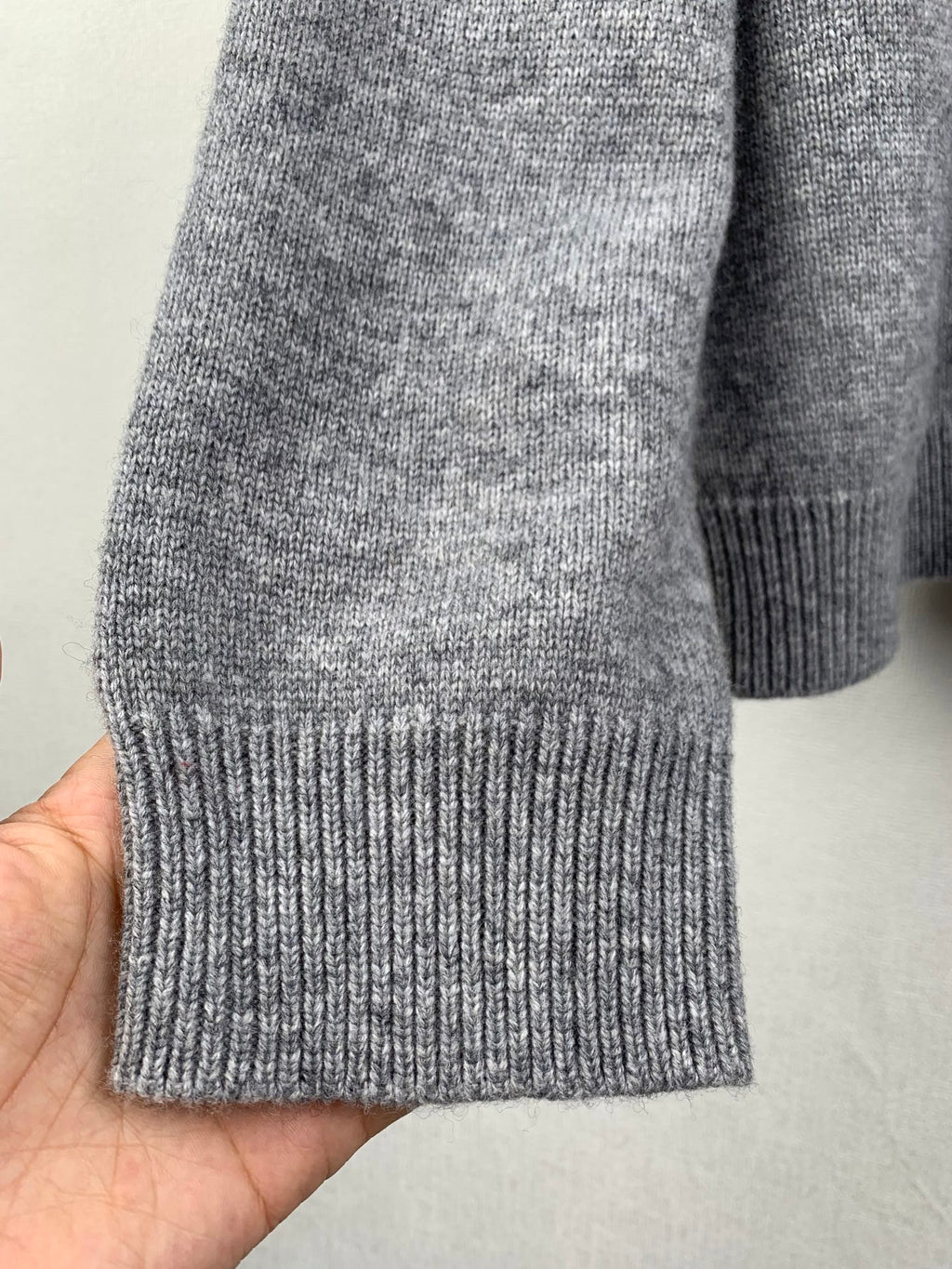 Gray knit sweater hem with ribbed cuffs and ribbed bottom band