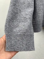 Gray knit sweater hem with ribbed cuffs and ribbed bottom band