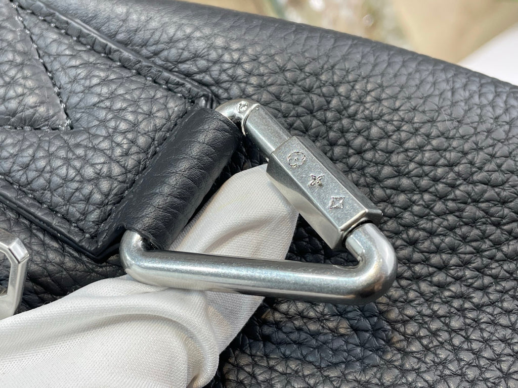 Louis Vuitton bag close-up of silver hook clasp on textured dark leather
