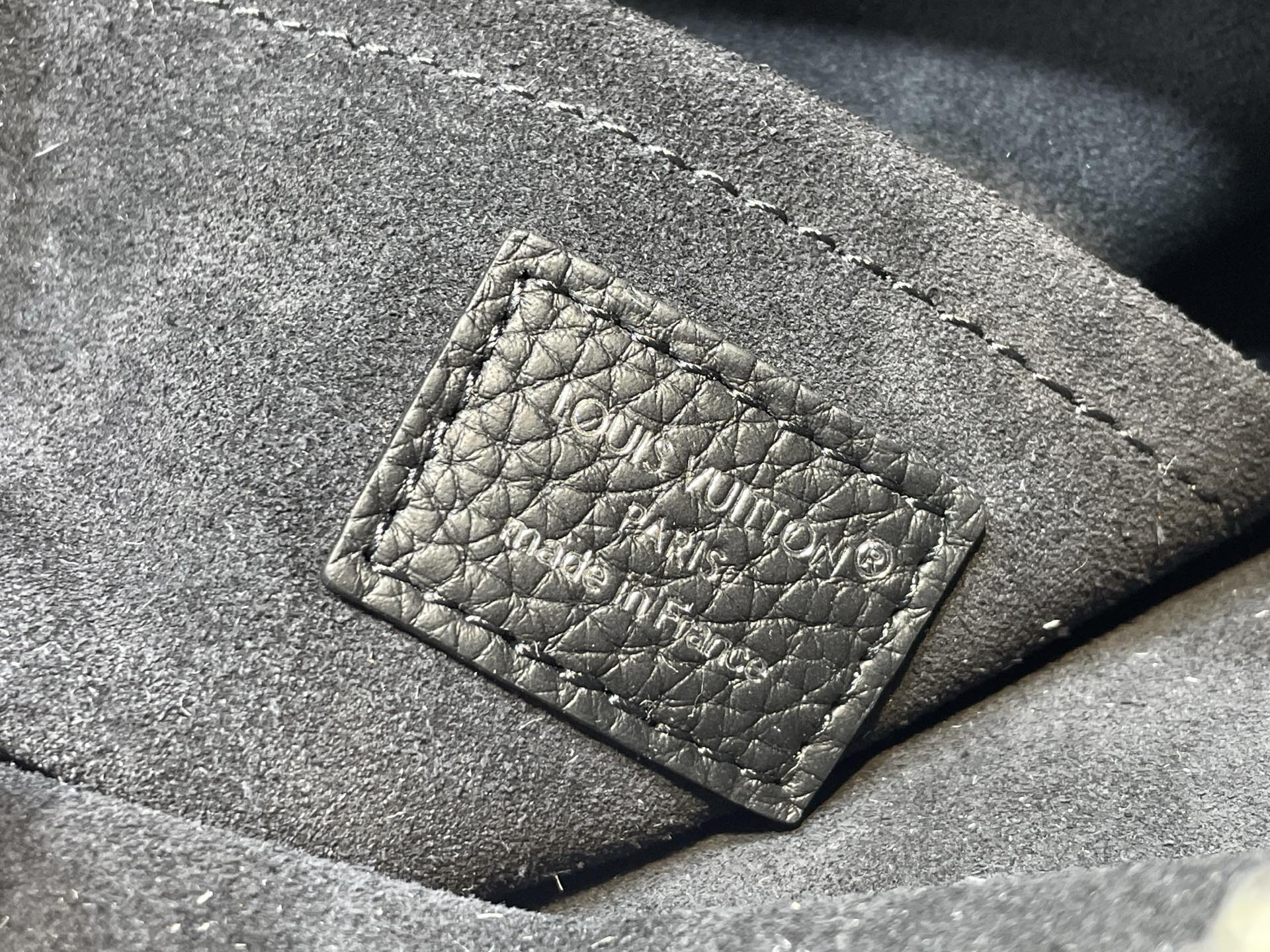 Louis Vuitton bag leather exterior with embossed monogram patch and contrast stitching