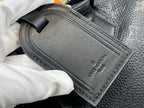 Black leather rectangular label with stitched edge and embossed logo on bag