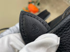 Black leather bag corner patch with small embossed logo detail