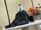 Black leather bucket-style handbag with short strap, long shoulder strap, and charm