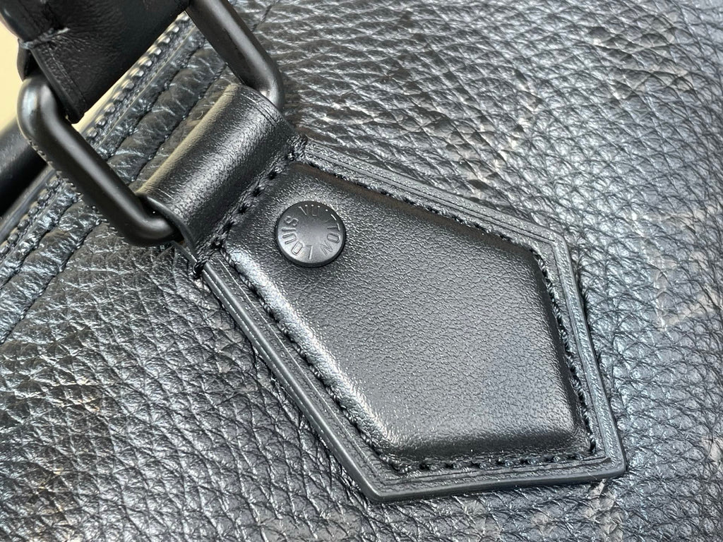 Black leather bag corner patch with snap closure on textured material
