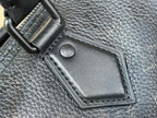 Black leather bag corner patch with snap closure on textured material