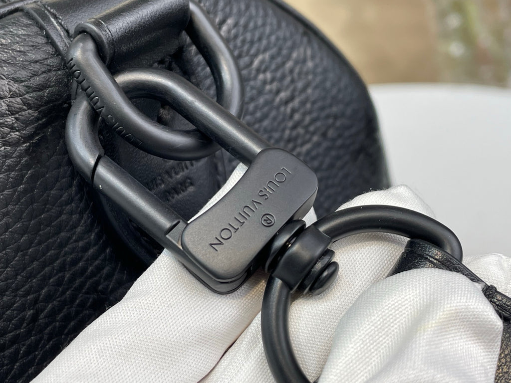 Black leather bag clasp with O-ring hardware and strap attachment detail