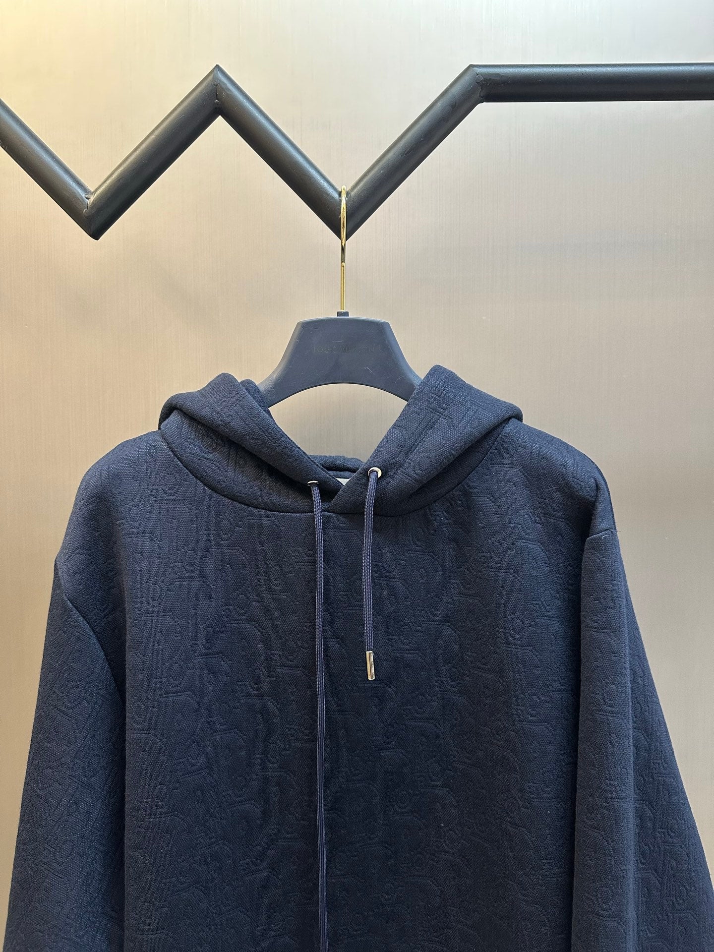 Navy blue zip-up hoodie with drawstring hood and subtle embossed pattern