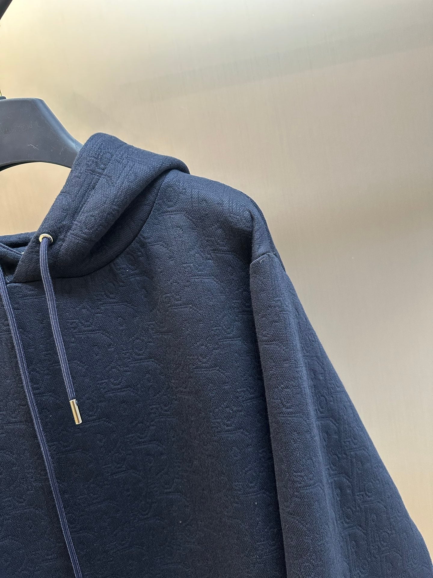 Navy blue hoodie with textured fabric and drawstring hood on the side