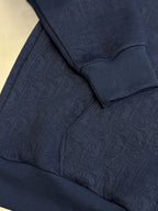 Navy blue hoodie sleeve and chest area with textured embossed pattern