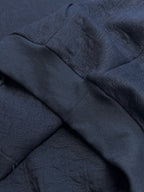 Navy blue hoodie fabric fold with textured embossed pattern