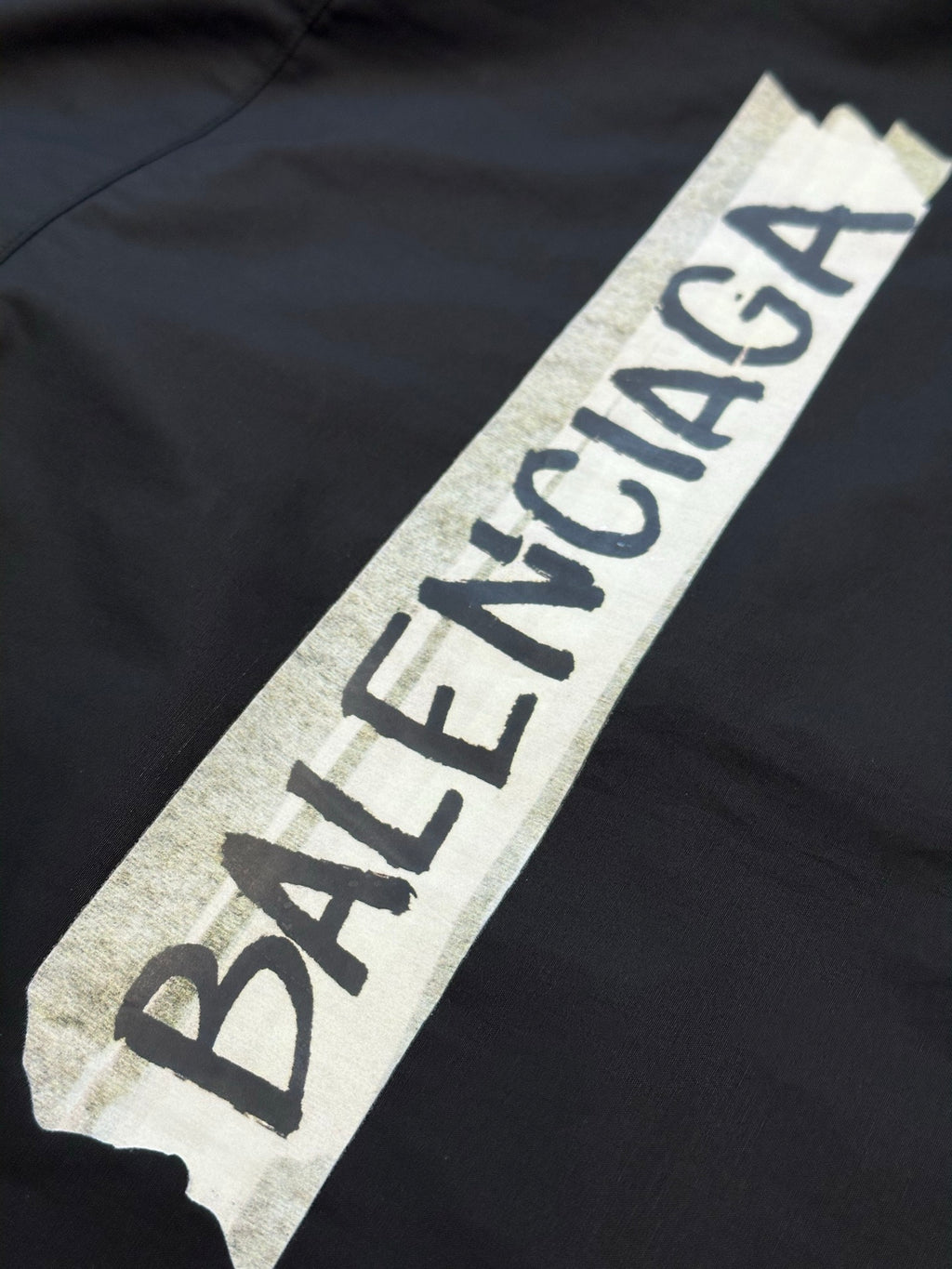 Dark charcoal shirt with large Balenciaga logo patch on chest area