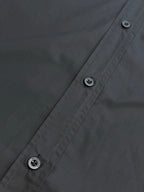 Dark charcoal button-up shirt front seam with two visible buttons and stitch lines