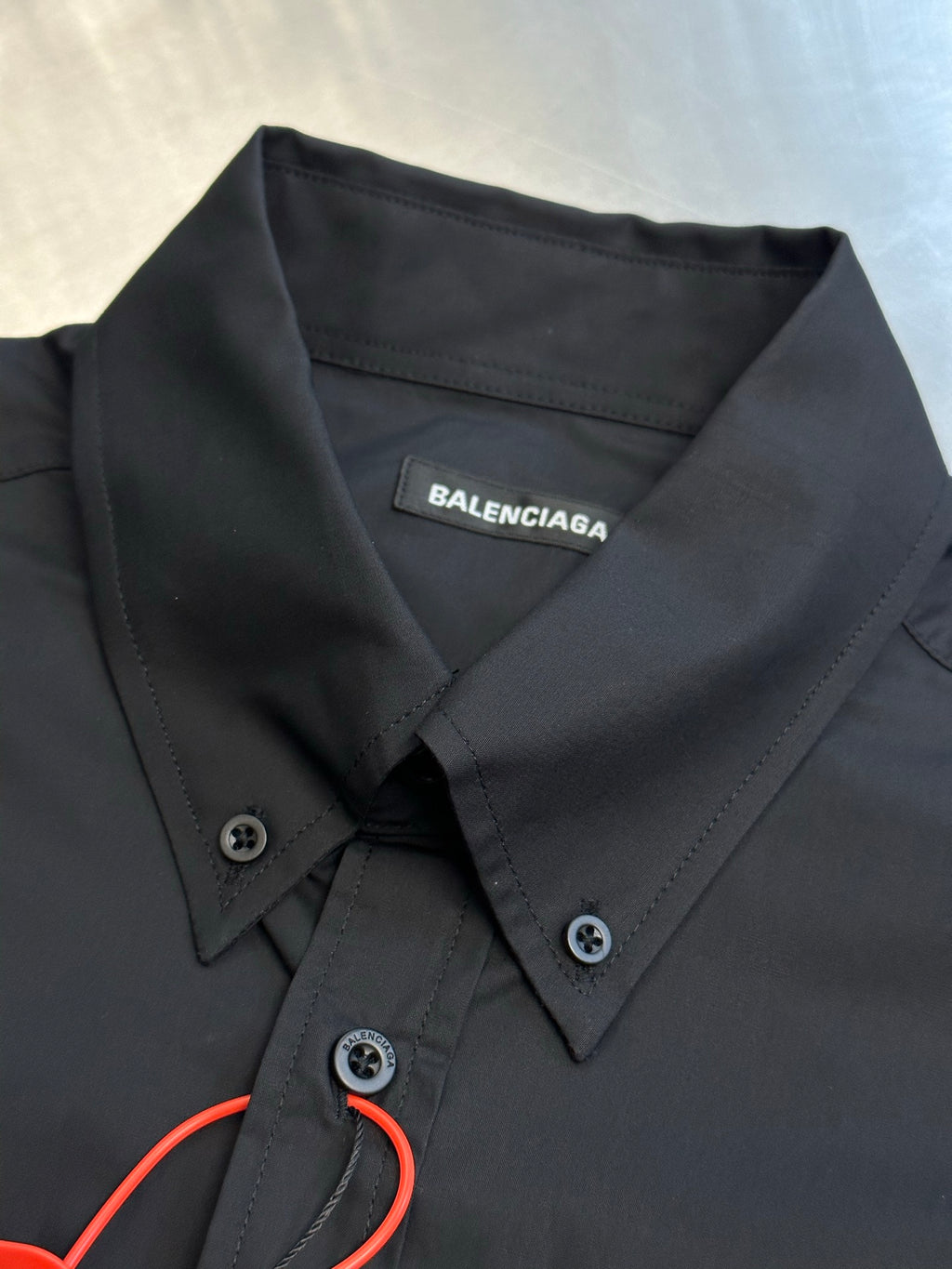Dark charcoal button-up shirt collar and placket with Balenciaga neck label