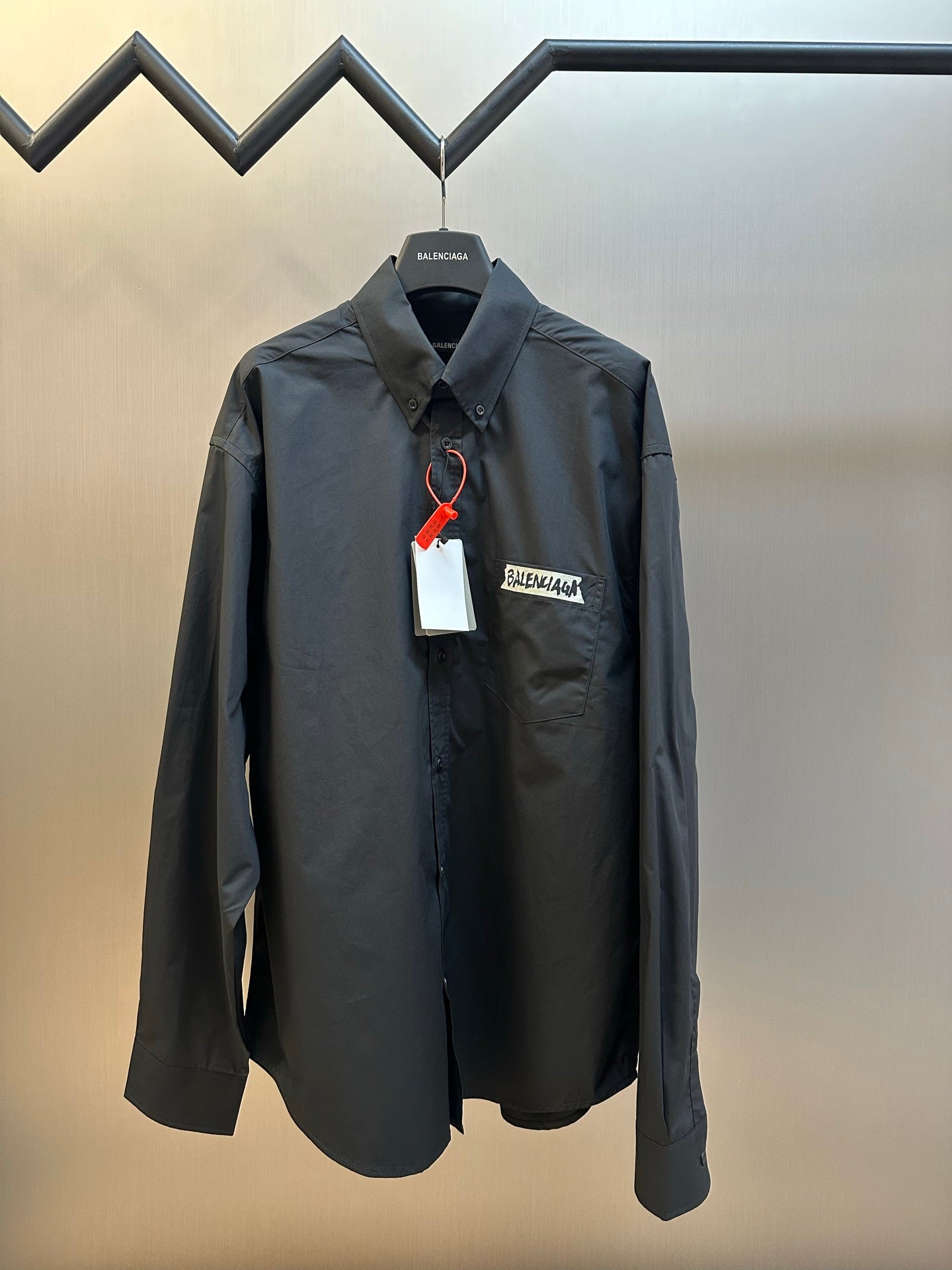 Dark charcoal long-sleeve button-up shirt with pointed collar and chest pocket logo label
