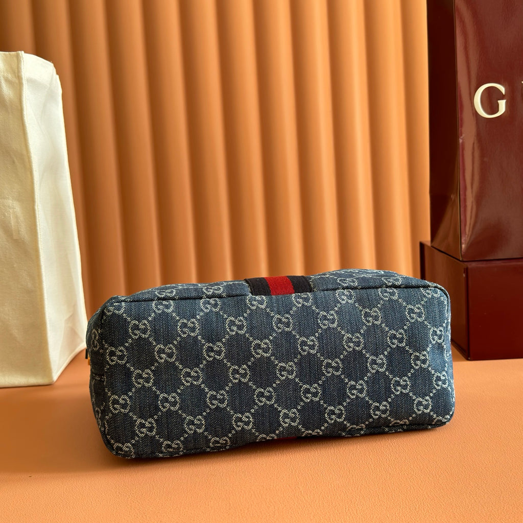 Gucci bag in blue GG canvas with red/black stripe, rounded zip-top silhouette.