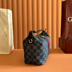 Gucci bag with blue GG canvas pattern, short handle, and gold eyelet hardware.