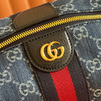 Gucci bag detail: gold GG emblem on brown leather patch beside zip track.