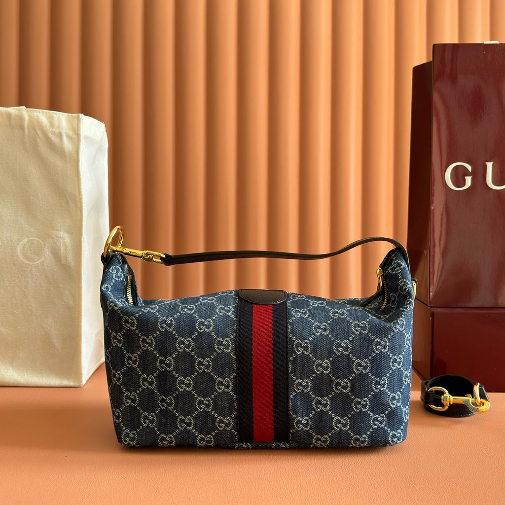Gucci bag in blue GG canvas with red/black stripe, structured top handles with gold hardware.