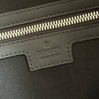 Gucci logo patch inside zippered compartment on dark duffel bag lining