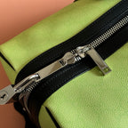 Lime duffel bag with black zipper pull and silver-tone hardware along top edge
