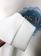 White sweatshirt sleeve and cuff with blue Versace print behind