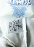 White sweatshirt care label stitched inside collar area with icons