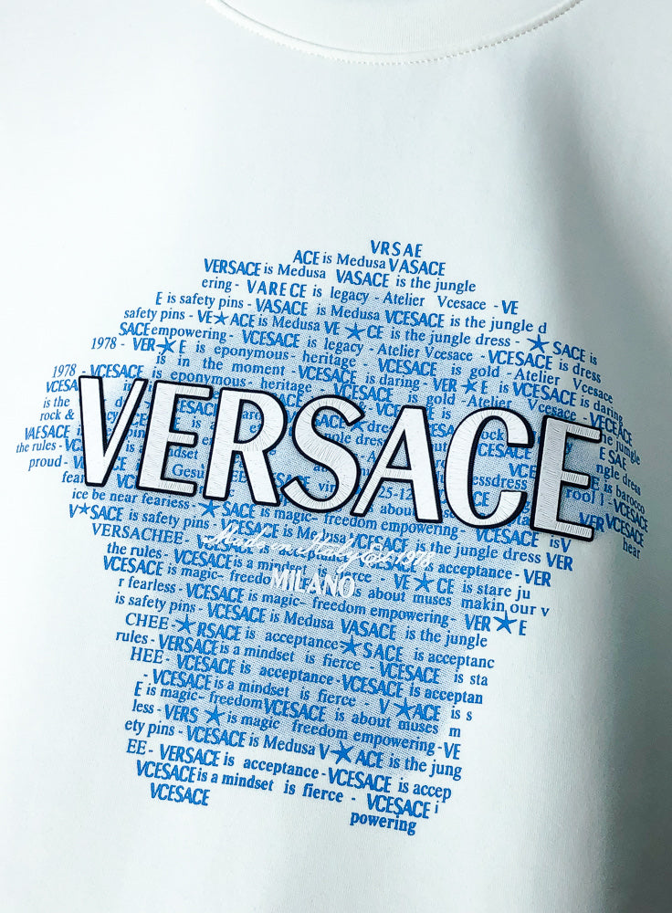 White sweatshirt with large blue Versace text graphic across the front