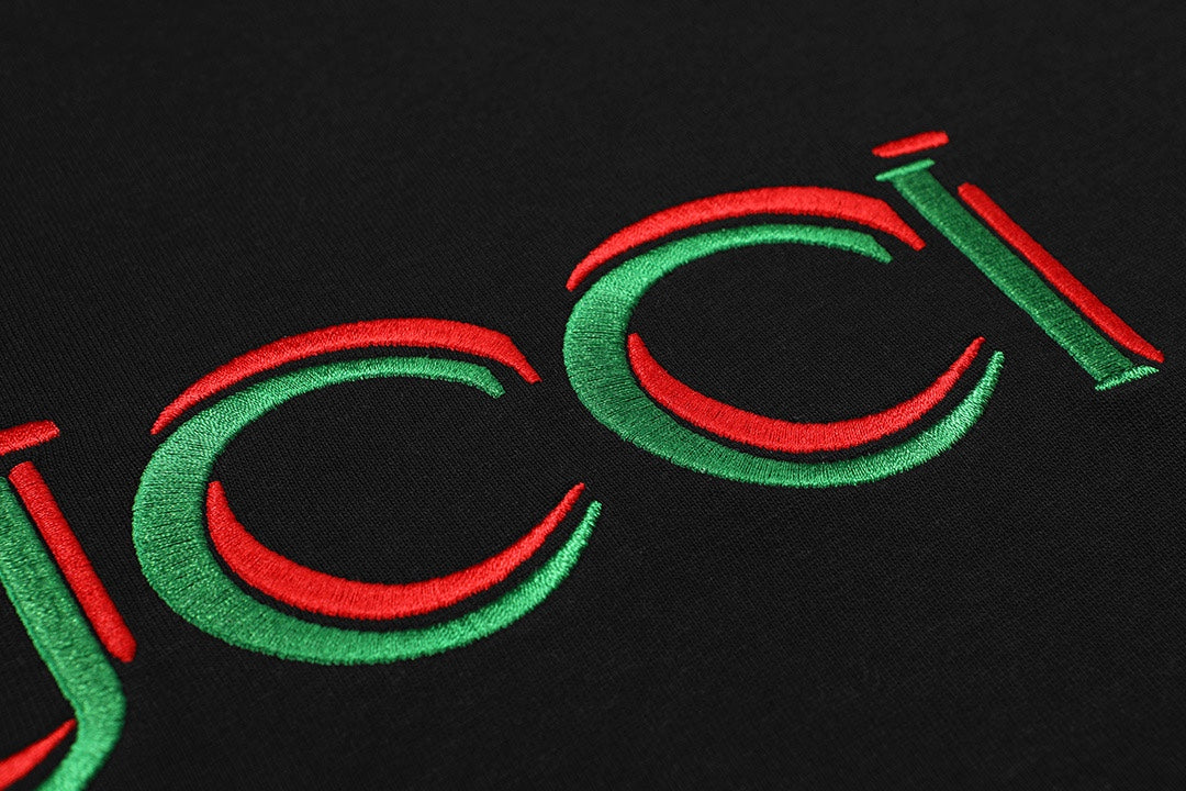 Gucci logo detail on black T-shirt with green outlines and red accents