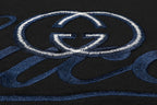 Close-up of blue-and-white Gucci emblem embroidery on black T-shirt