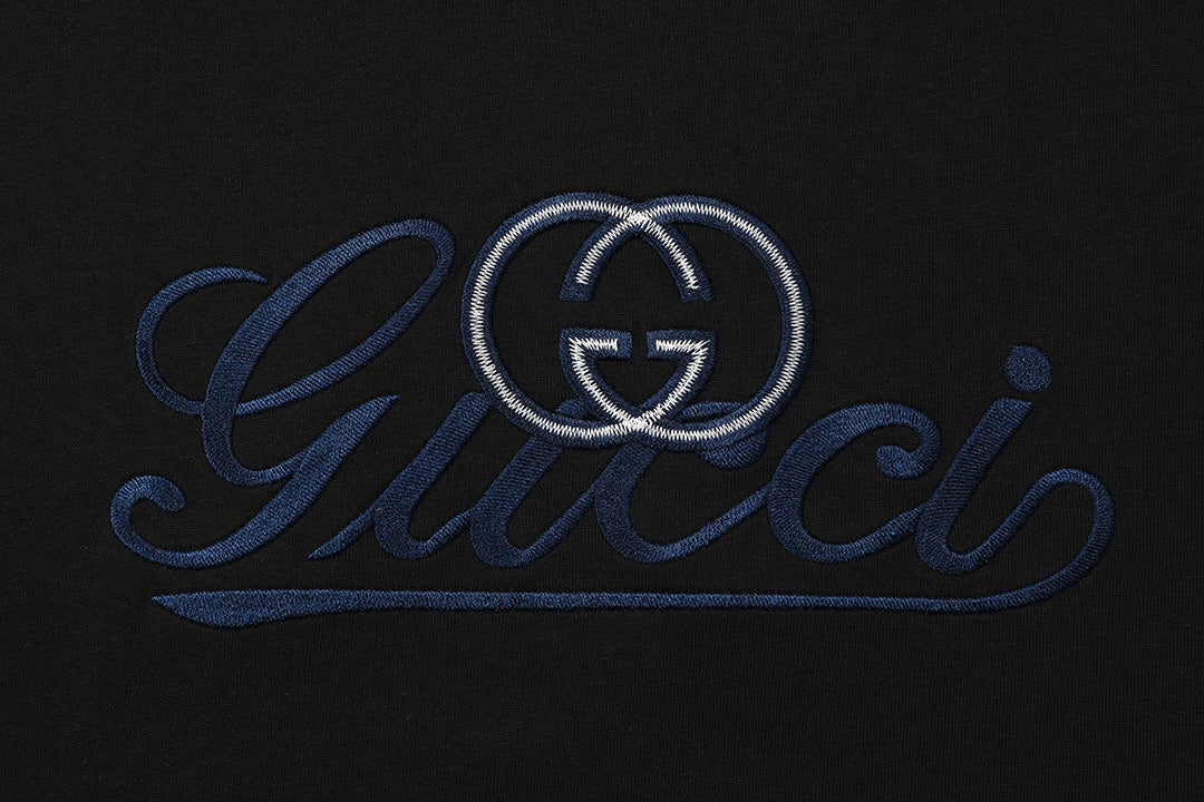 Black T-shirt with large blue Gucci logo embroidery and heart emblem