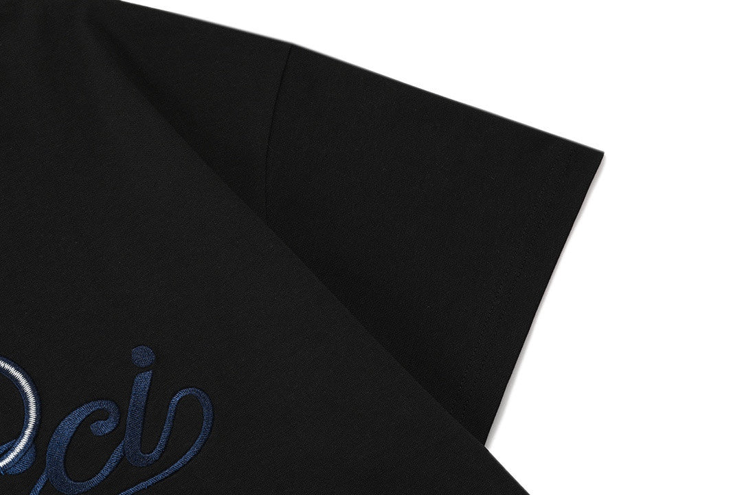 Black T-shirt sleeve with partial blue Gucci logo embroidery