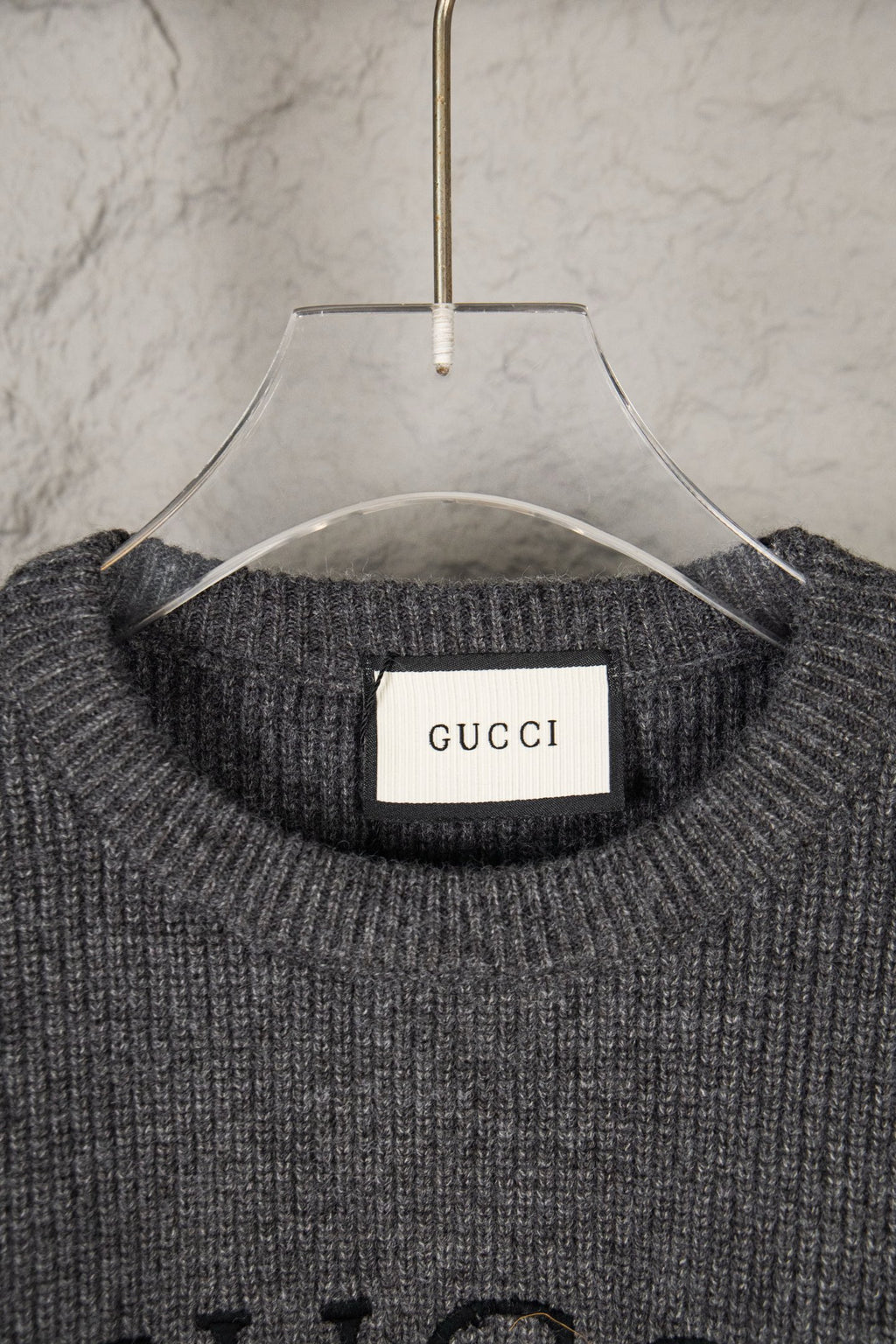 Dark gray knit sweater neckline with GUCCI brand label