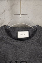 Dark gray knit sweater neckline with GUCCI brand label