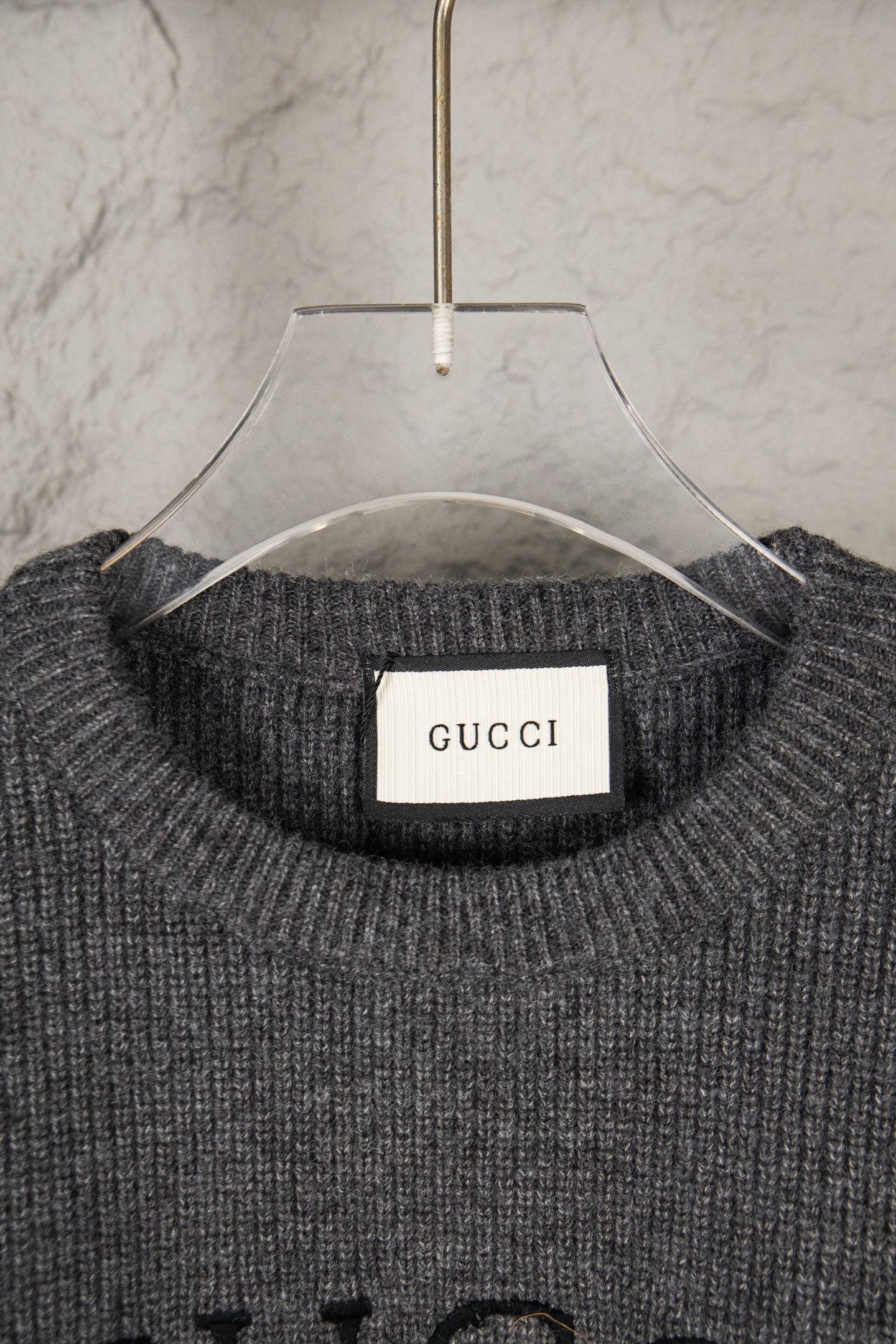 Dark gray knit sweater neckline with GUCCI brand label