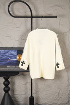 Off-white knit sweater back with small black clover cross appliques