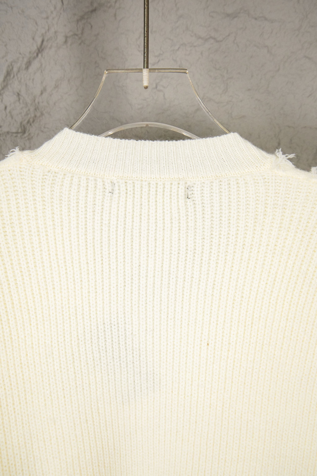 Off-white knit sweater back view with ribbed knit and fringe hem