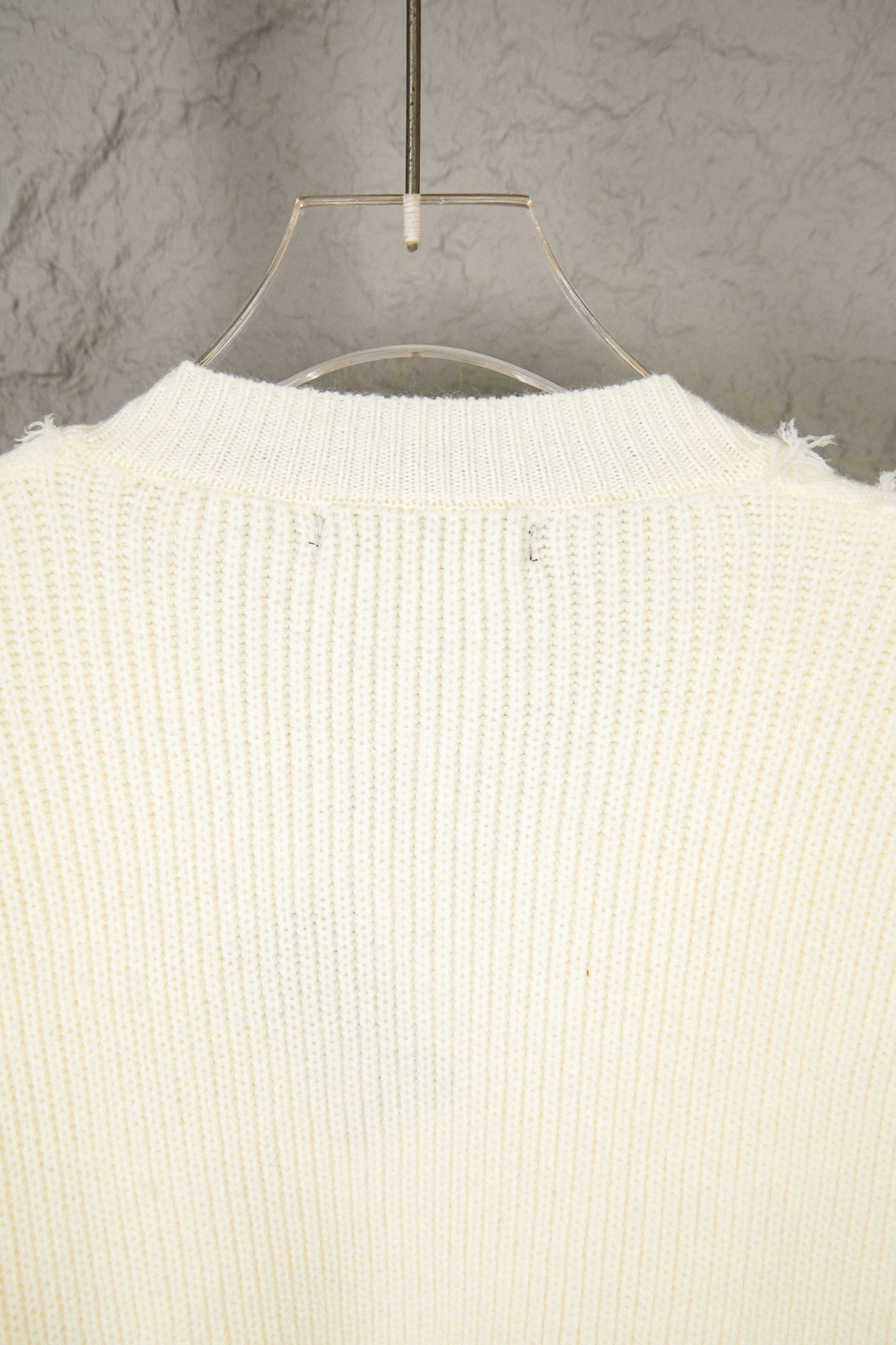 Off-white knit sweater back view with ribbed knit and fringe hem