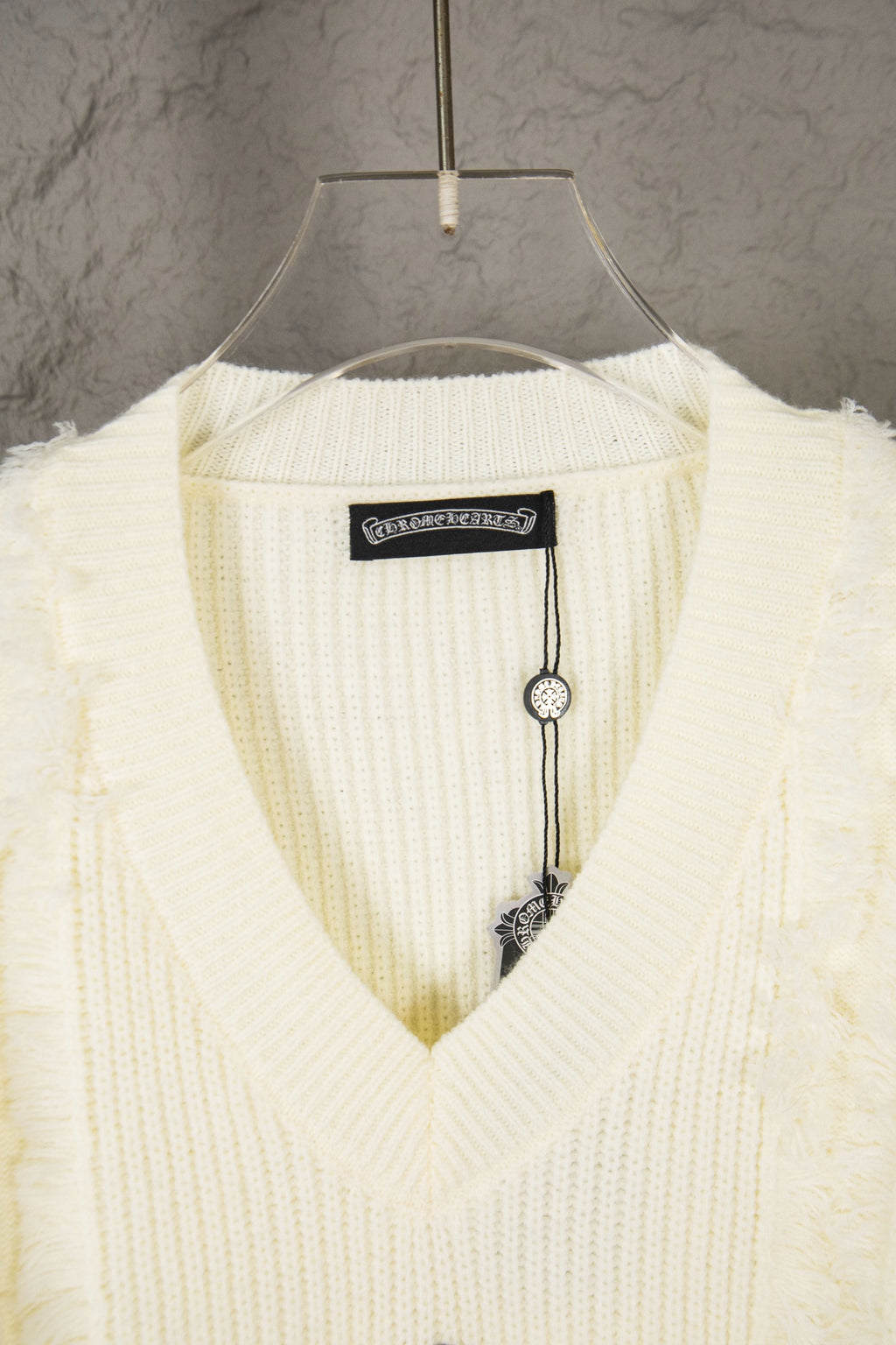 Off-white V-neck knit sweater collar with brand label and hanging tag detail