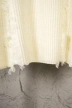 Off-white knit sweater hem with fringe edge and ribbed knit texture