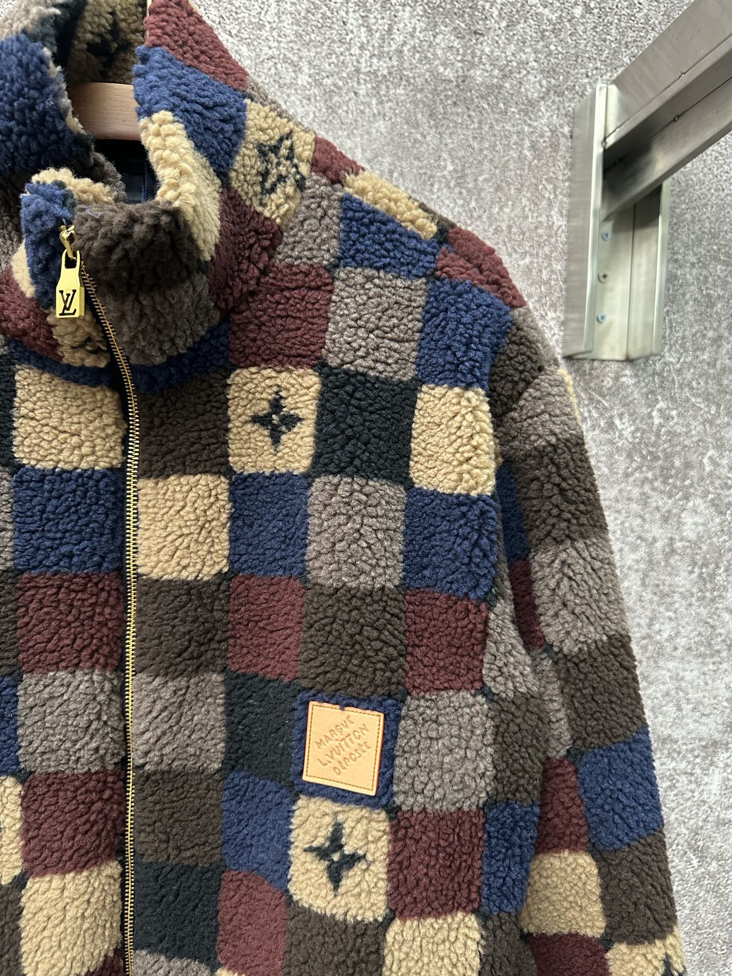 Long-sleeve check sherpa jacket close-up, zip front with logo patch detail