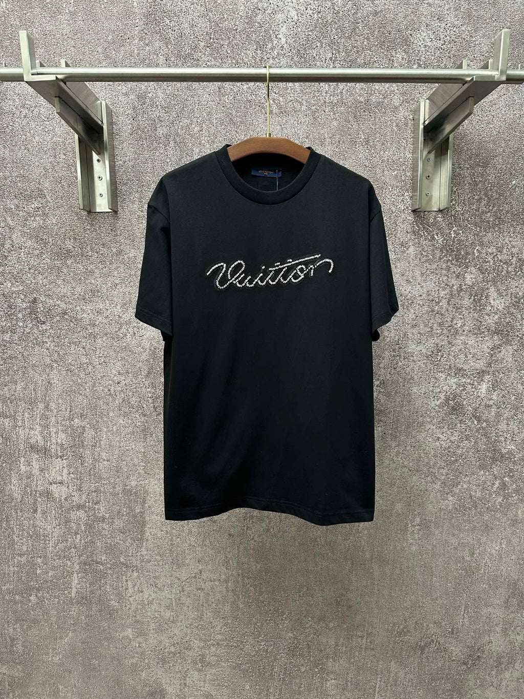 Dark T-shirt with crew neck, short sleeves, and white Louis Vuitton script on the chest