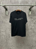 Dark T-shirt with crew neck, short sleeves, and white Louis Vuitton script on the chest