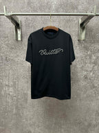 Dark T-shirt with crew neck, short sleeves, and white Louis Vuitton script on the chest