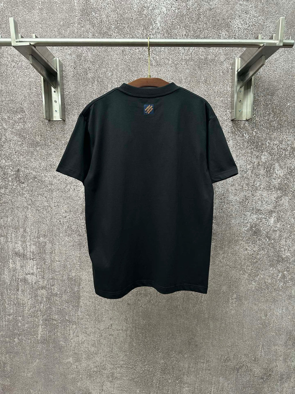 Dark T-shirt with crew neck and small crest logo at upper back